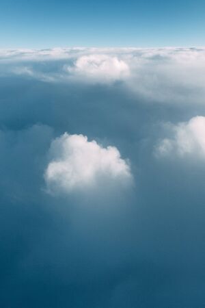View from the plane at altitude, flying over the clouds. Sunset in the sky, a journey from the...