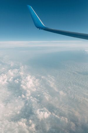 View from the plane at altitude, flying over the clouds. Sunset in the sky, a journey from the...