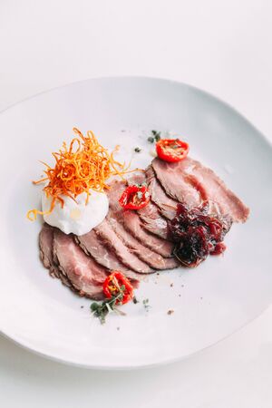 Dish with cream cheese. Restaurant serving delicacy. Sliced meat on a plate. The carbonate from fresh meat. の写真素材