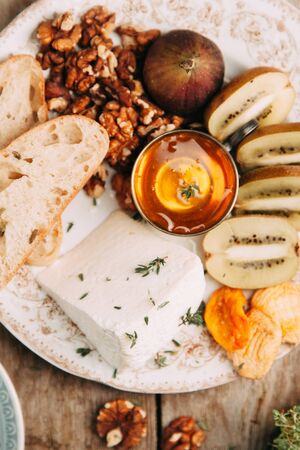 Flatley cheese plate with figs. Snacks for the company. Set of cheeses on a plate with honey and...