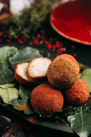 Balls of goat cheese in red pepper. Homemade natural hard cheese on a plate. Farm diet products.の写真素材