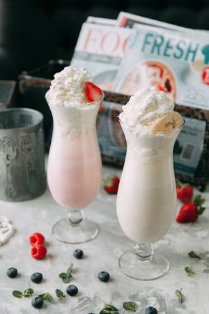 Milkshakes with blueberries and raspberries. Food styling with decor on a wooden background.の写真素材