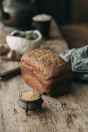 Fresh rye and grain bread on dark wooden background. Food styling and cooking with fresh...