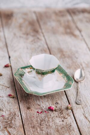 tea set in composition with flowers and marshmallows. Coffee mug on a saucer, a teapot and a sugar bowl. Filmed in the interiorの写真素材