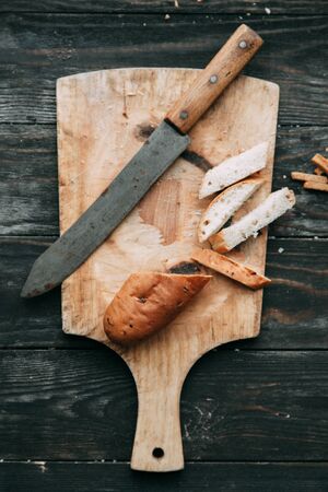 Loaf and crackers with salt on a black wooden background, with the fabric in the composition. Spices and sliced breadの写真素材