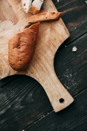 Loaf and crackers with salt on a black wooden background, with the fabric in the composition. Spices and sliced breadの写真素材