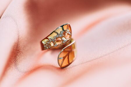 handmade jewelry made of gold with precious stones on an abstract backgroundの写真素材