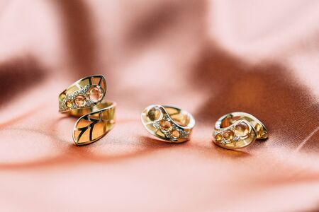 handmade jewelry made of gold with precious stones on an abstract background