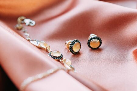 handmade jewelry made of gold with precious stones on an abstract backgroundの写真素材