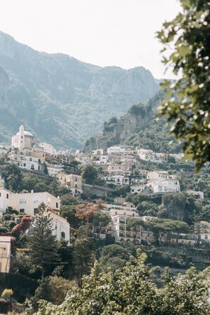 The coast of Positano, Amalfi in Italy. Panorama of the evening city and the streets with shops and cafes. Houses by the sea and the beach. Ancient architecture and temples. View from a postcard on topの写真素材