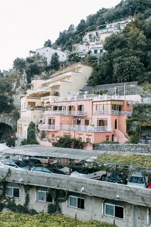 The coast of Positano, Amalfi in Italy. Panorama of the evening city and the streets with shops and cafes. Houses by the sea and the beach. Ancient architecture and temples. View from a postcard on topの写真素材