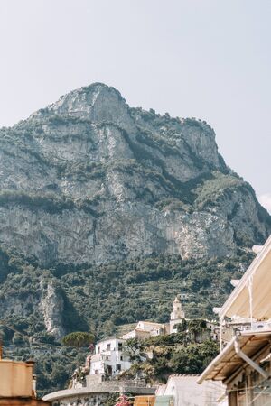 The coast of Positano, Amalfi in Italy. Panorama of the evening city and the streets with shops and cafes. Houses by the sea and the beach. Ancient architecture and temples. View from a postcard on topの写真素材