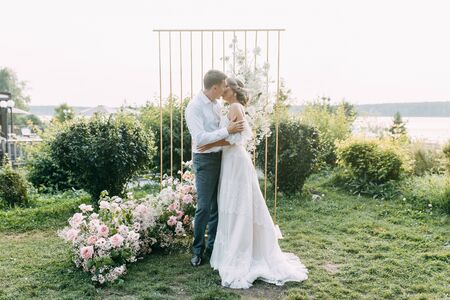  Beautiful couple at sunset in the Park. Wedding ceremony with arch in the forest.の写真素材