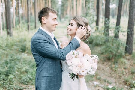 Modern ceremony in European style. Beautiful wedding couple in atmospheric forest with rocks.の写真素材