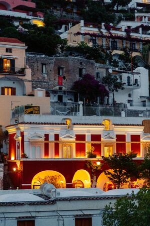 The coast of Positano, Amalfi in Italy. Panorama of the evening city and the streets with shops and cafes. Houses by the sea and the beach. Ancient architecture and temples. View from a postcard on topの写真素材