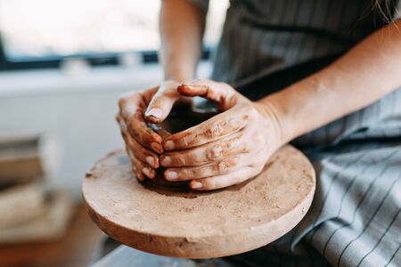 Hands of a girl on a Potters wheel with clay. The process of creating pottery.の写真素材