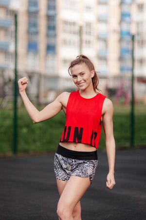 sporting a young girl in the gym and the stadium, warming up before exercise and listening to musicの写真素材