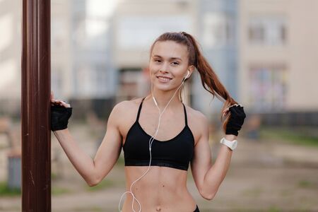 sporting a young girl in the gym and the stadium, warming up before exercise and listening to musicの写真素材