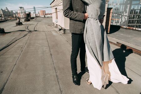 Pre-wedding shooting on the roof of the building, on the street. Happy couple laughing, hugging and...