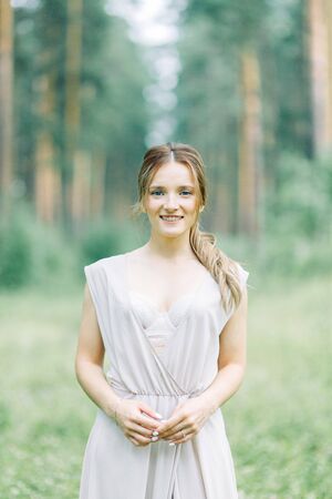 Boudoir photo shoot of the bride in the woods with a bouquet. Flying dress and beautiful girl in the Park.の写真素材