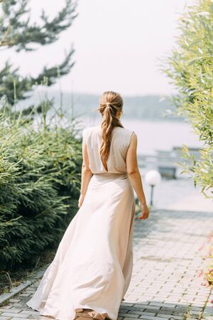 Boudoir photo shoot of the bride in the Park with a bouquet. A flying dress and a beautiful girl by the lake.の写真素材