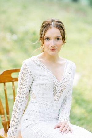 The bride in a wedding dress in nature with a bouquet. Boudoir photo shoot in pine lemu in the style of fine art.の写真素材