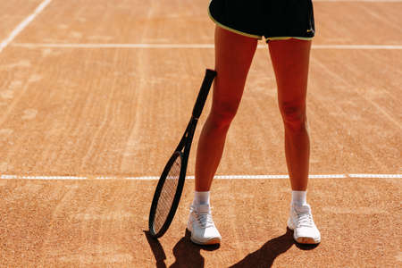 Beautiful girl athlete on the tennis court. Tennis training, racket and ball, concept.の写真素材