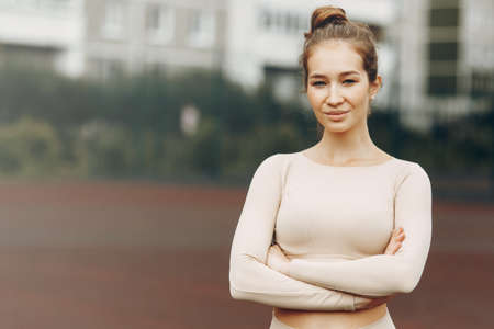 Young fitness woman in gym clothes after a workout in the open air. Portrait of a sporty smiling...