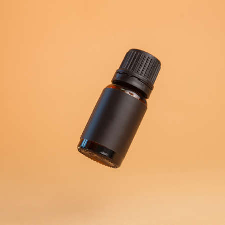 A jar of eyebrow cosmetics on an isolated background. A black jar of henna hangs in the air.の写真素材