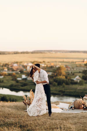 Beautiful wedding couple in nature in boho style. Wedding in the European style of fineart at sunset.の写真素材