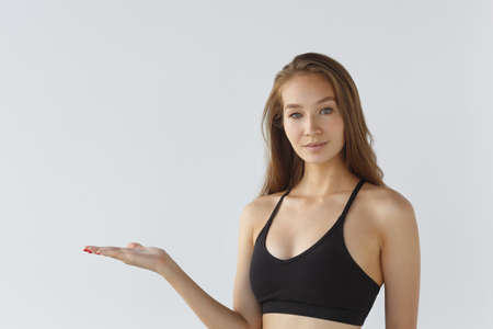 Portrait of a young female athlete on a white background, pointing. Training sports motivation the concept of lifestyle.の写真素材