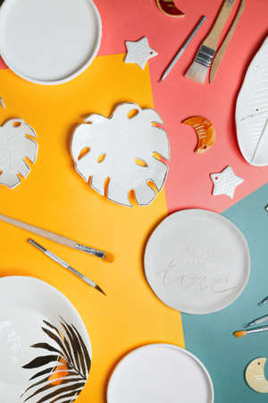 Flat lay of ceramic dishes on a bright coloredの写真素材