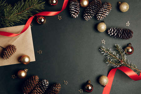 Christmas background with fir branches and pine cones on flatley wood background and top view. Greeting card frame, with an empty space in the center.の写真素材