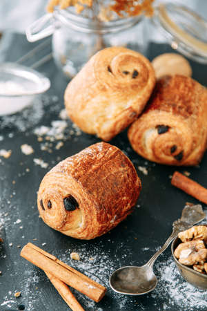 Sweet dessert with chocolate chips on a wooden background. Puff pastry pie with chocolate wrapped in a roll.の写真素材