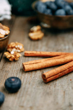 Cinnamon sticks and walnuts on a wooden table.