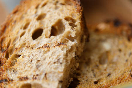 The texture of the bread with blurred background. Close-up on traditional bread with cereals and seeds.の写真素材