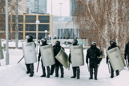 Yekaterinburg, Russia - January 23, 2021: Riot police run to disperse civilians. Military with weapons and shields in winter.のeditorial素材