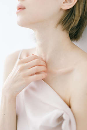 Expressive look of the model on a sensual face, neutral makeup. Portrait of a beautiful woman in an evening dress on a light background.の写真素材