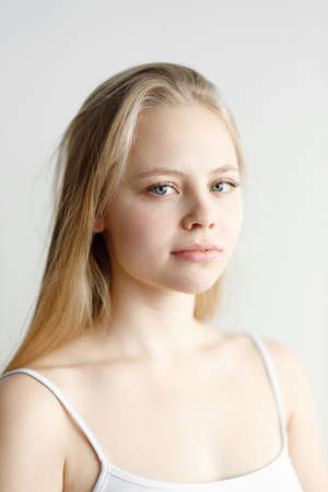 Beautiful young girl in sports clothes on a white background. Portrait of an athlete, motivation of...