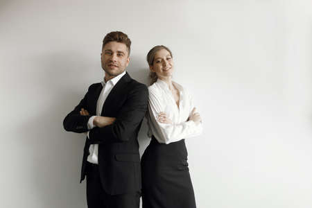 Business portrait of a couple in a business style. A man and a woman standing back to back on a white background.の写真素材
