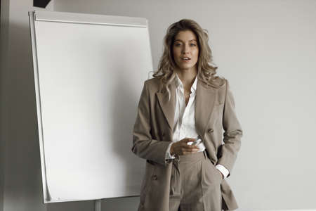 Portrait of a smiling girl on a white background. Close-up of a businesswoman writing in a flipchart.の写真素材