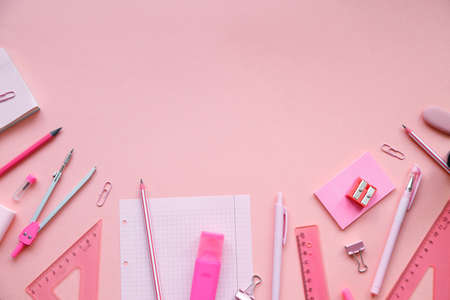 Stationary concept, Flat Lay top view Photo of school supplies scissors, pencils, paper clips, calculator, sticky note, stapler and notepad in pastel tone on pink background with copy space.の写真素材