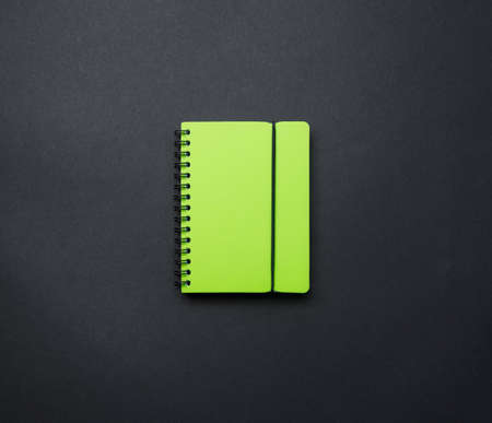 Office desk flat layout, set of items. An open notebook on a black background top view, a school...