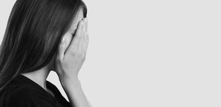 Stop domestic violence against women. The girl covers her face with her hands and cries.の写真素材