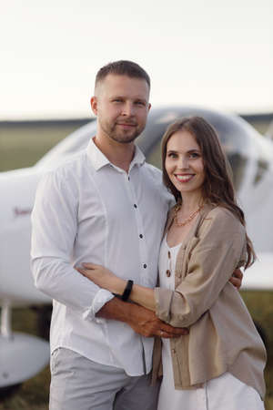 Smiling people and a private plane in the background. A couple of lovers, in the cockpit on their own plane.の写真素材