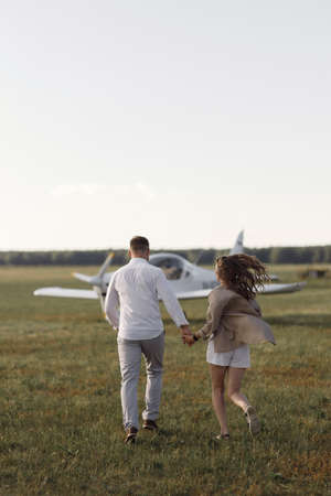 Smiling people and a private plane in the background. A couple of lovers, in the cockpit on their own plane.の写真素材
