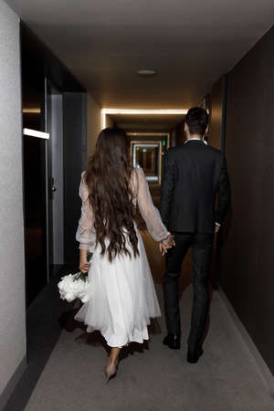 Newlyweds with a dark hotel, a wedding photo shoot. Stylish wedding, shooting with flashes.の写真素材