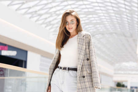 A modern business woman in an office with a neutral background. A young girl, a break at work, a work situation.の写真素材