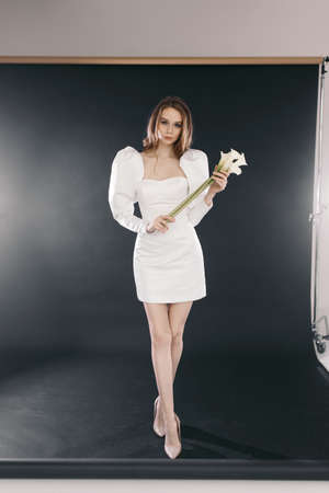 Modern stylish dress, on a black background in the studio. Portrait of a beautiful bride in a wedding dress on a dark background.の写真素材