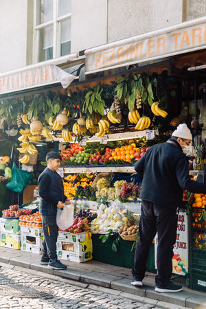 ISTANBUL, TURKEY - NOVEMBER 15: The seller weighs the goods. A street stall with fresh fruit.のeditorial素材